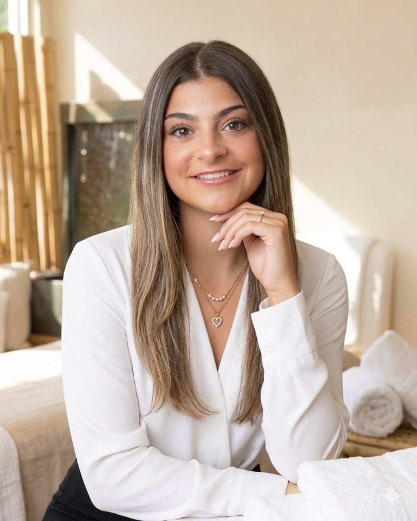 Woman in a white blazer sitting in a cozy room with light decor